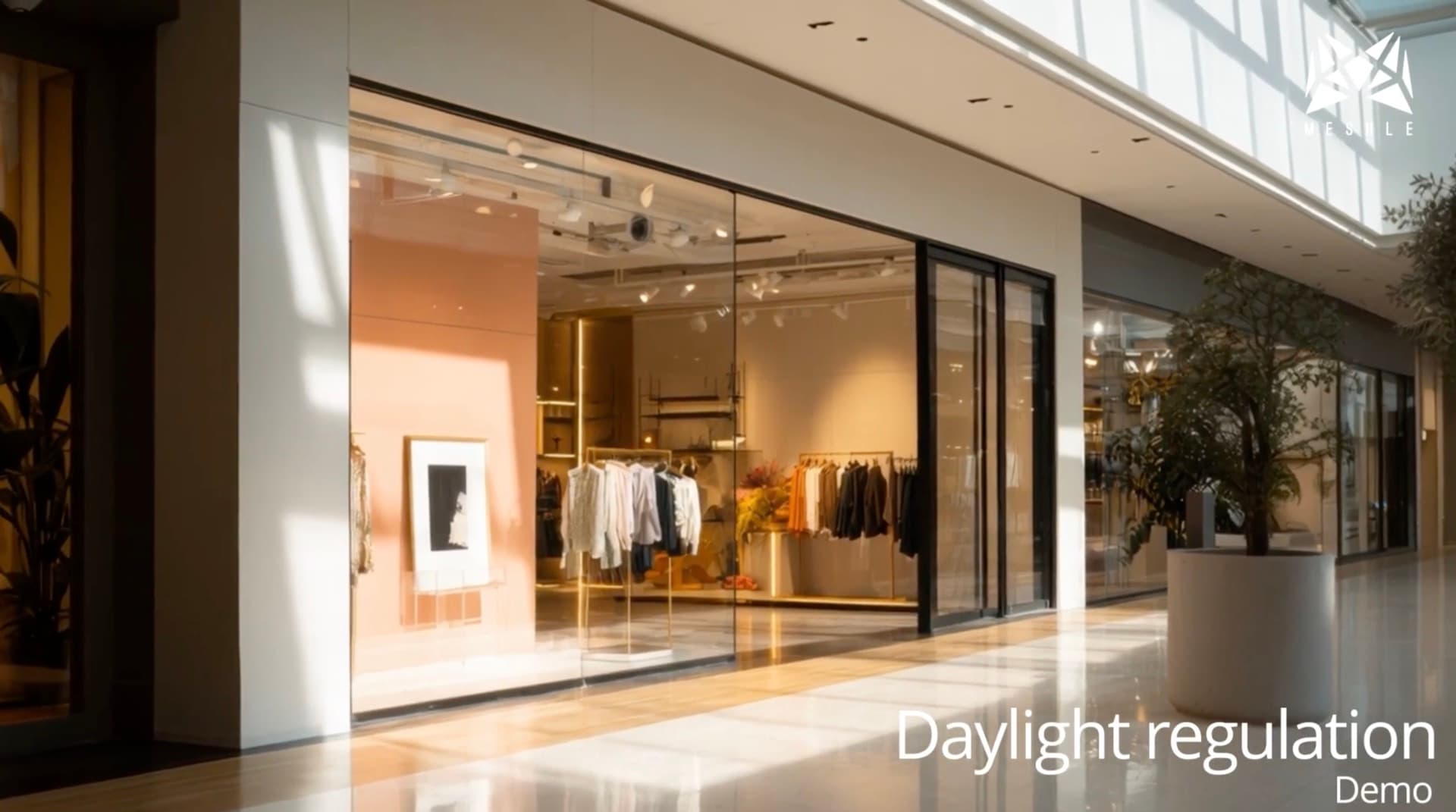 Storefront lighting under a mall's glass roof, dimmed by MESHLE daylight harvesting to match the natural daylight